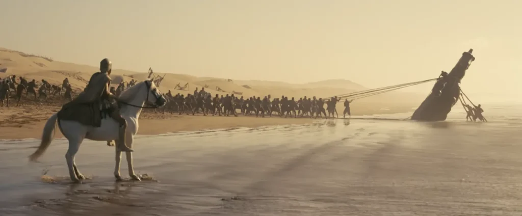 جنود يقودون حصانًا خشبيًا قرب الشاطئ في لقطة من تريلر فيلم The Odyssey
